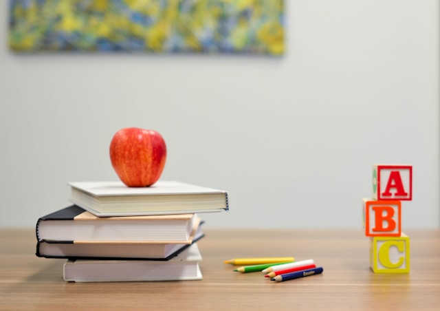 Red apple fruit on four pyle books photo