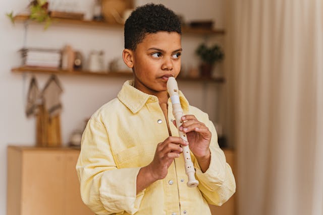 Boy in Yellow Long Sleeve Shirt Playing Flute