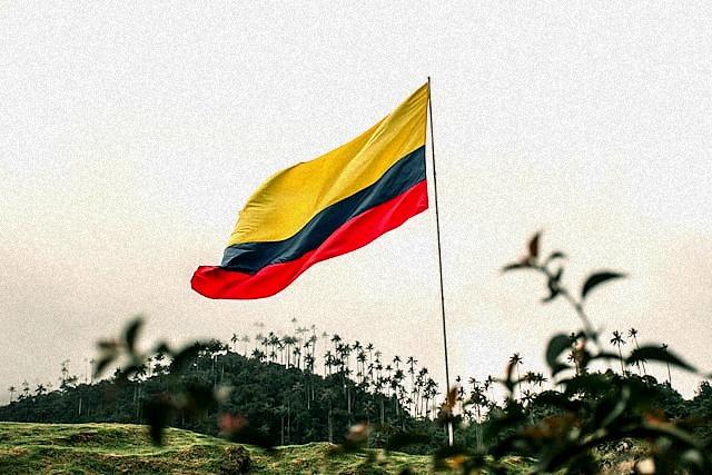 A flag flying in the wind on top of a hill